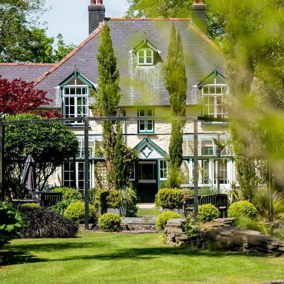 The stone exterior of The Cors Country House in Laugharne showing its unique gardens.