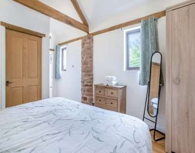 Bedroom with an exposed stone pillar at Court Park Barn, near Chepstow