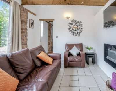 Cosy seating area with an electric fire at Court Park Barn, near Chepstow
