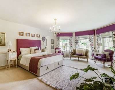 Spacious master bedroom with a bay window at Llwynhelig House, near Cowbridge