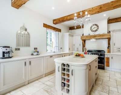 Country kitchen with a range cooker, island and exposed beams at Llwynhelig House, Vale of Glamorgan