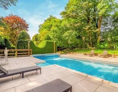 Heated outdoor swimming pool with loungers at Llwynhelig House, near Cowbridge