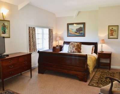 Bedroom with a mahogany sleigh bed at The Court, near Beaumaris, Anglesey