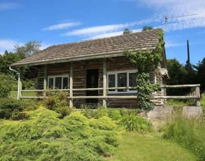 Log lodge exterior with climbing roses at The Garden House, near Monmouth