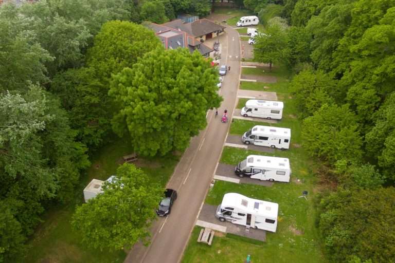 Aerial view of Cardiff Caravan and Camping Park, motorhomes lined along a tree-shaded road in Pontcanna Fields