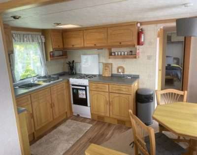 Kitchen with cooker and dining table in Hilltop Hideaway, Aberystwyth