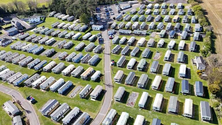 Aerial view of The Bay Caravan Park, rows of static holiday caravans in 27 acres of clifftop grounds at Lavernock