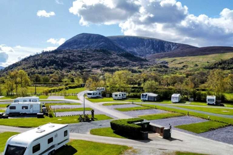 Hardstanding pitches with motorhomes and caravans below the mountain at Bryn Gloch, Caernarfon