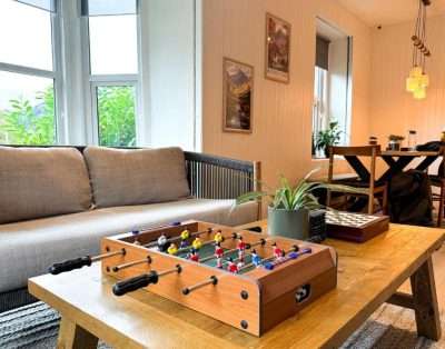 Guest lounge at Base Camp Snowdonia with a sofa, table football and house plants