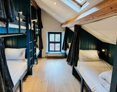 Attic dormitory at Base Camp Snowdonia with bunk beds under a sloping ceiling and a roof window