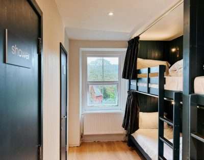 Bunk room at Base Camp Snowdonia with a window, radiator and the door to the landing